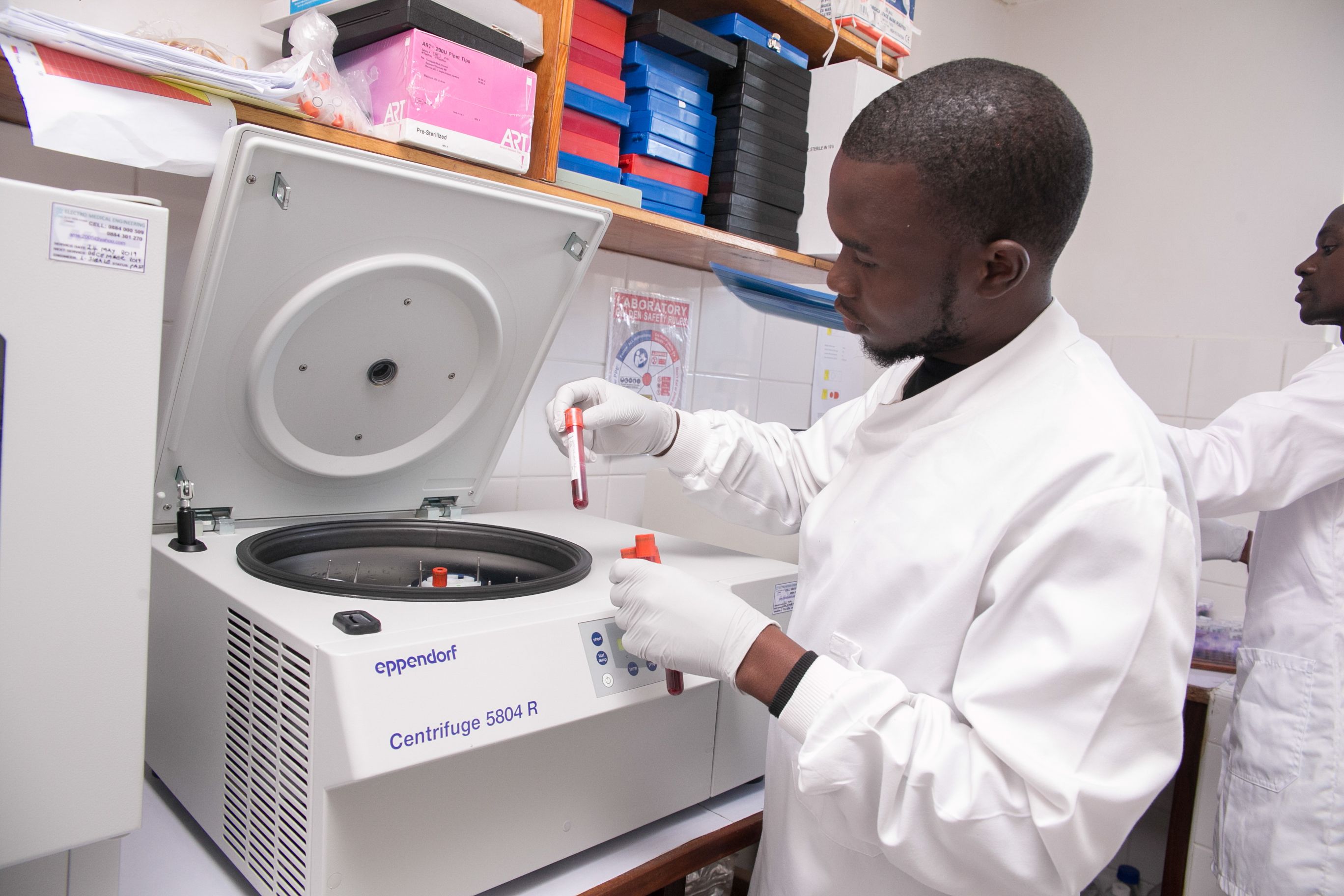 Laboratory technician working on a centrifugre in MLW labs Copyright Malawi Liverpool Wellcome Programme 2018 (3)