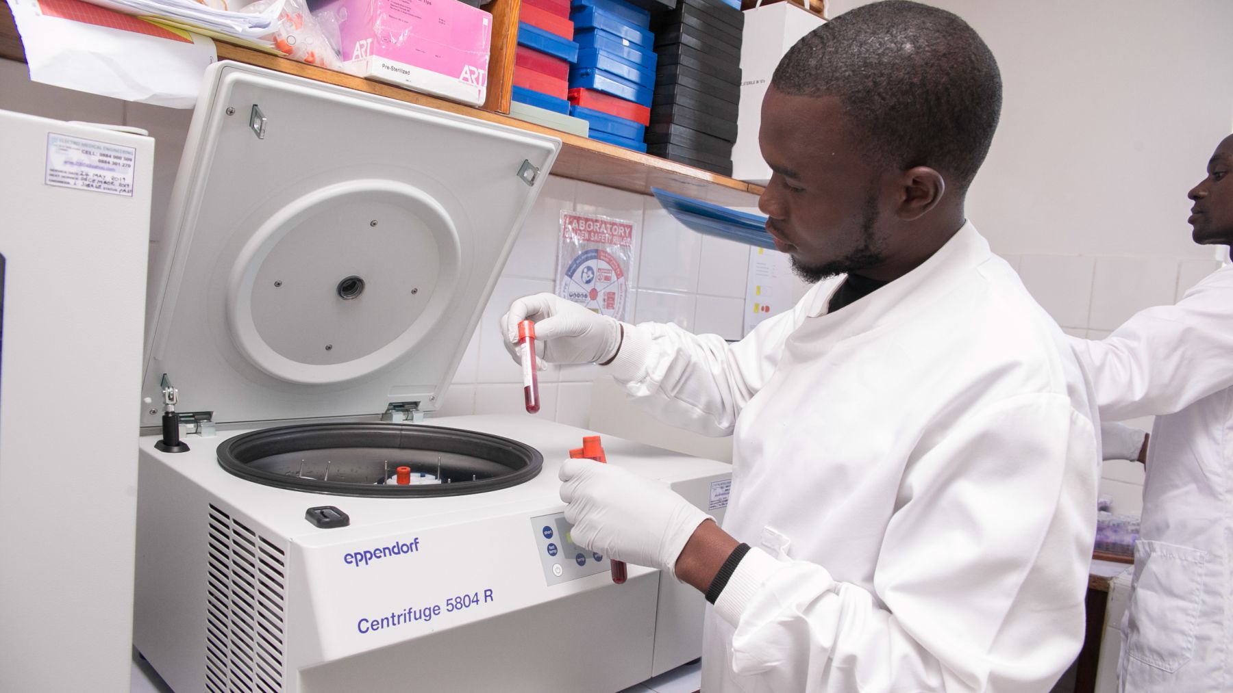 Laboratory technician working on a centrifugre in MLW labs Copyright Malawi Liverpool Wellcome Programme 2018 (3)